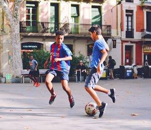 kids playing football on a city square in Portugal