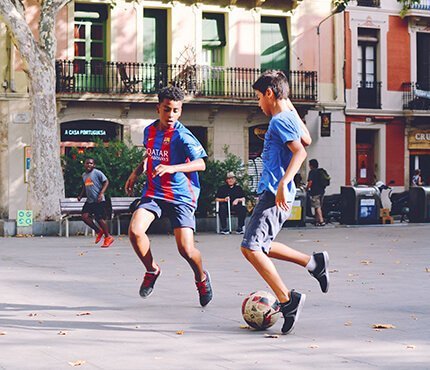 kids playing football on a city square in Portugal